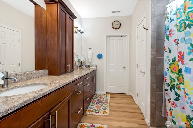 bathroom with vanity, a shower with shower curtain, and wood-type flooring