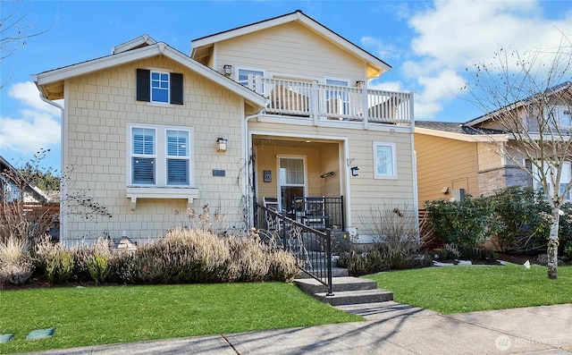 view of front of home featuring a balcony and a front yard