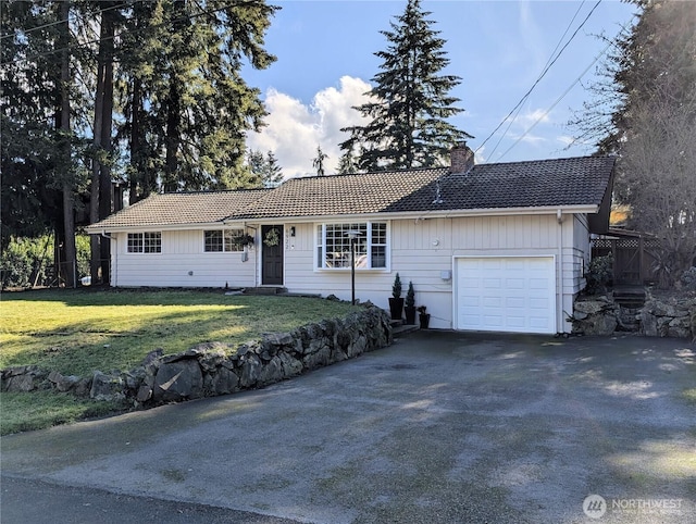 ranch-style house featuring a chimney, an attached garage, a front yard, driveway, and a tiled roof