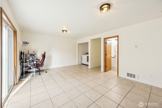 interior space featuring light tile patterned floors and washer / dryer