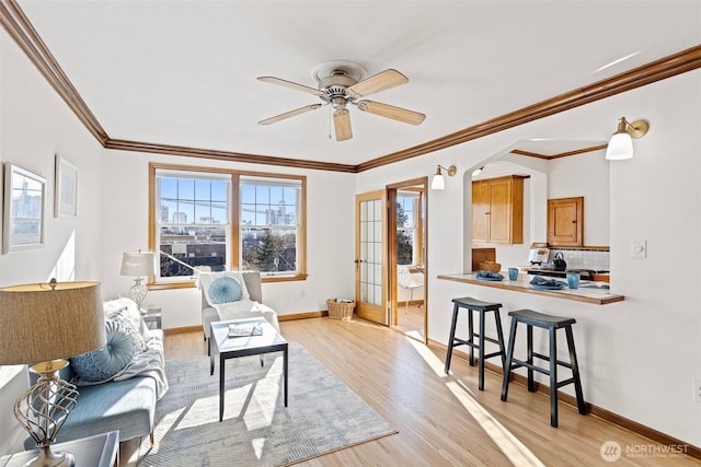 living room featuring light wood-type flooring, ornamental molding, and ceiling fan