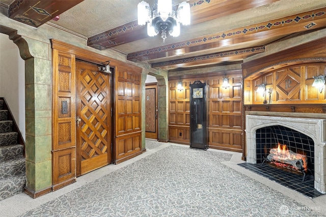 living room featuring carpet, a high end fireplace, and beamed ceiling