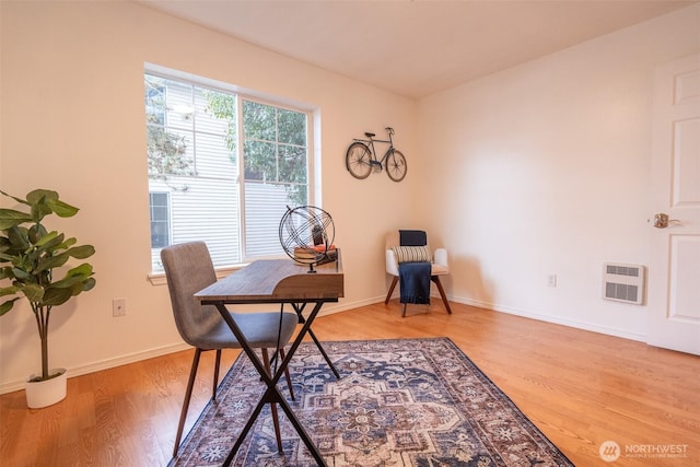 office space featuring heating unit and light hardwood / wood-style flooring