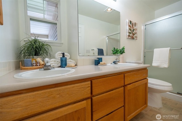 bathroom with vanity, toilet, and a shower with door