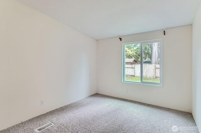 carpeted spare room featuring visible vents