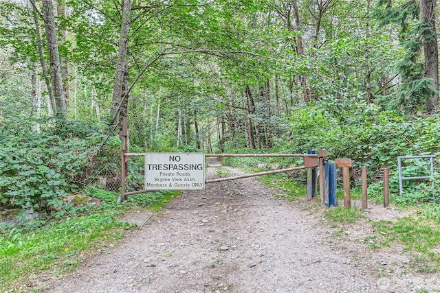 view of gate with a wooded view