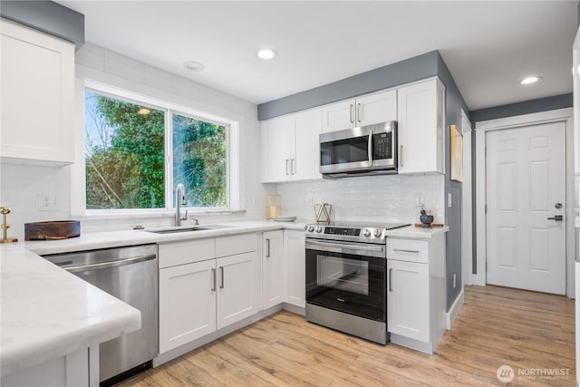 kitchen featuring white cabinetry, appliances with stainless steel finishes, and light hardwood / wood-style flooring