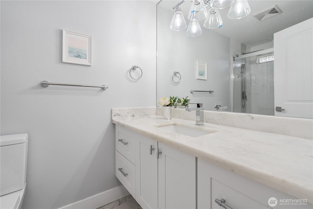 bathroom featuring a shower with door, vanity, and toilet