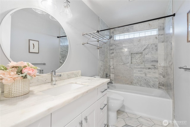 full bathroom featuring vanity, tile patterned floors, toilet, and tiled shower / bath