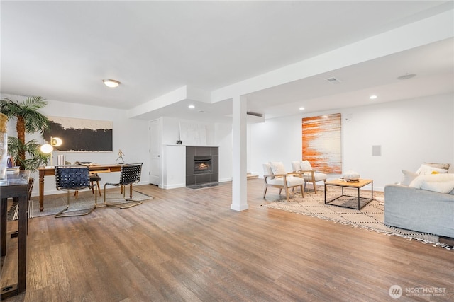 living room with hardwood / wood-style flooring and a tile fireplace