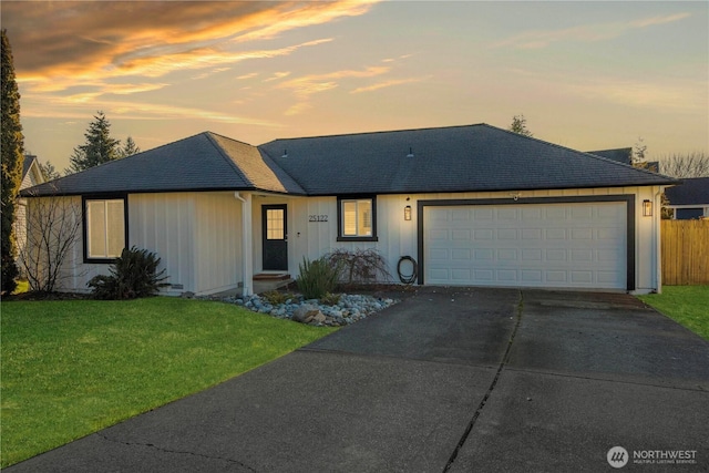 ranch-style home with a garage and a yard