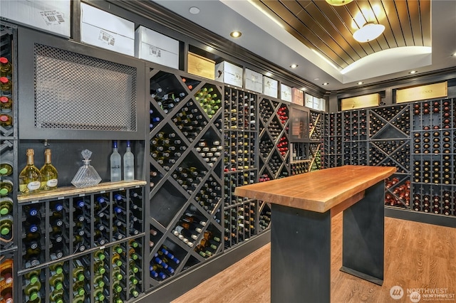 wine room featuring a tray ceiling, hardwood / wood-style floors, and wooden ceiling