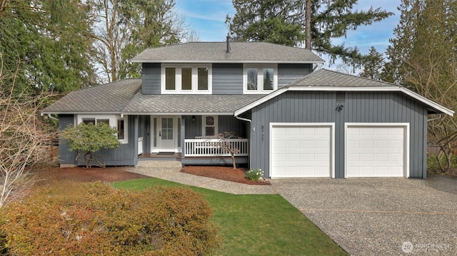 traditional-style home with a garage, roof with shingles, covered porch, and aphalt driveway