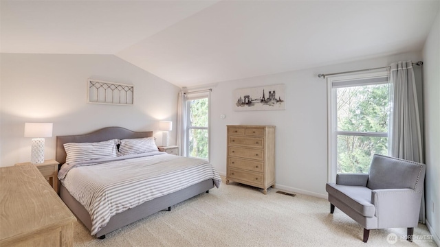 bedroom with light carpet, visible vents, baseboards, and lofted ceiling