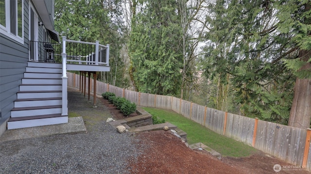 view of yard with a deck, stairs, and a fenced backyard