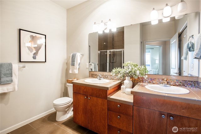 full bathroom featuring double vanity, tile patterned flooring, a sink, and a shower stall