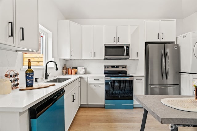 kitchen featuring sink, light hardwood / wood-style floors, white cabinets, and appliances with stainless steel finishes