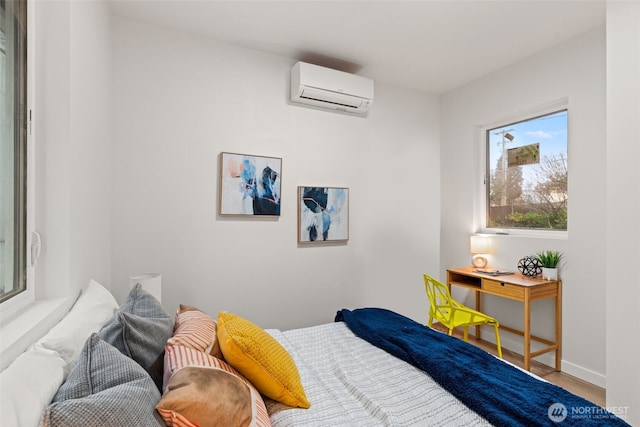 bedroom featuring hardwood / wood-style floors and a wall unit AC