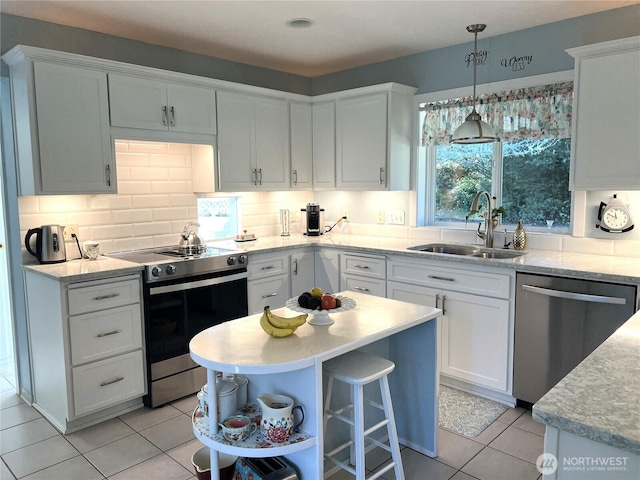 kitchen featuring white cabinetry, appliances with stainless steel finishes, tasteful backsplash, and a sink