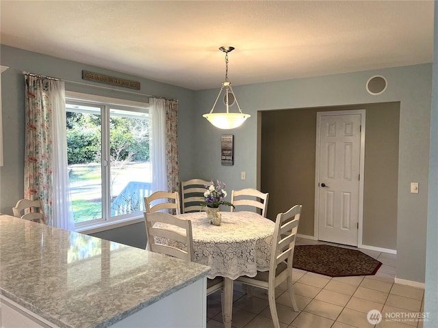 dining room with light tile patterned floors and baseboards