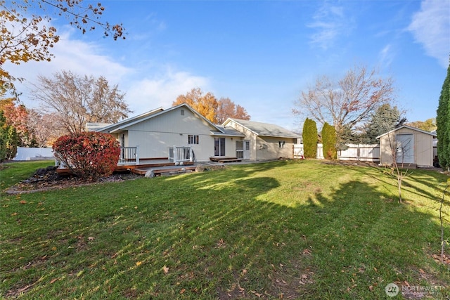 9447 Vernal Ave SE, Moses Lake, WA 98837 - rear view of house with a wooden deck, a storage unit, and a lawn