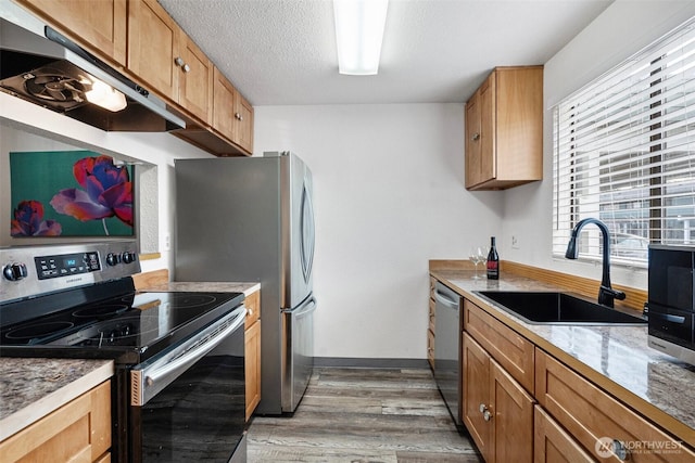 kitchen featuring sink, hardwood / wood-style floors, a textured ceiling, and appliances with stainless steel finishes