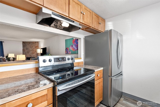 kitchen featuring stainless steel appliances, a textured ceiling, and light wood-type flooring