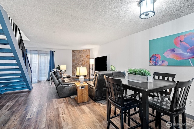 dining room featuring hardwood / wood-style floors and a textured ceiling