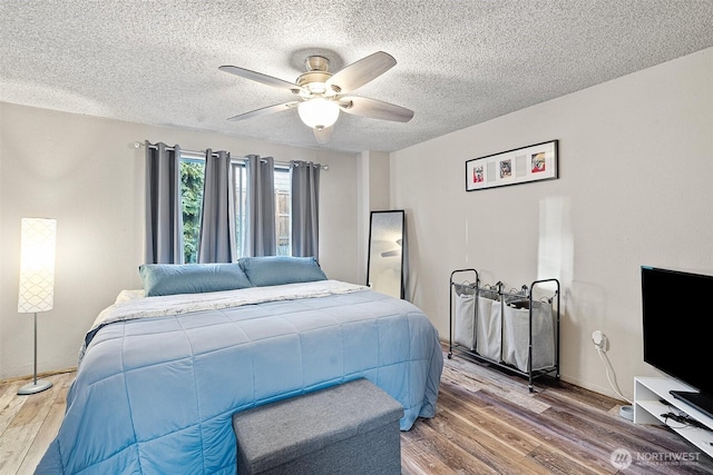 bedroom with wood-type flooring, ceiling fan, and a textured ceiling