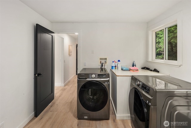 clothes washing area featuring washer and dryer and light wood-type flooring