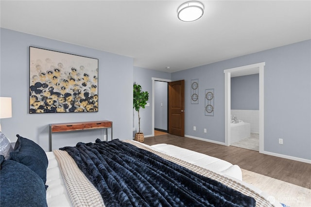 bedroom with hardwood / wood-style flooring and ensuite bath