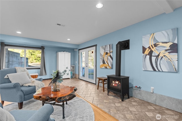 living room with french doors and a wood stove