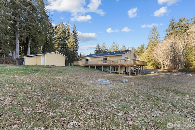 back of house featuring a wooden deck and a yard