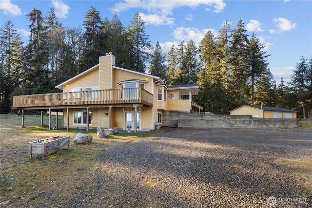 back of house with a garage and a deck