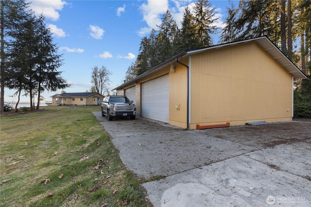 view of side of property with a garage and a lawn