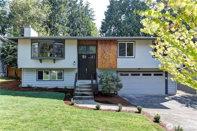 bi-level home with a garage and a front lawn