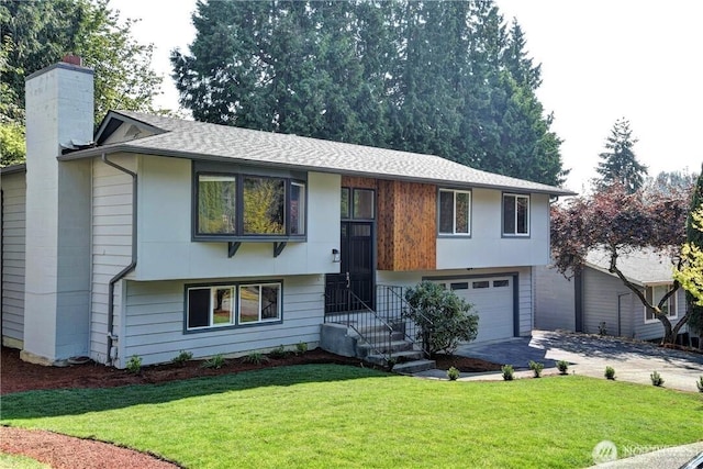 raised ranch with a garage and a front lawn