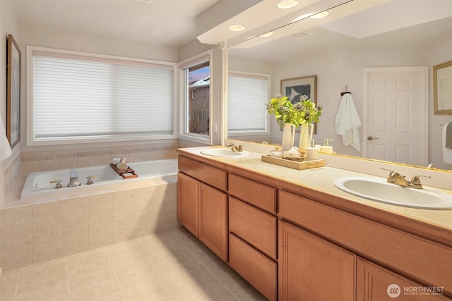 bathroom featuring vanity, tile patterned flooring, and tiled tub