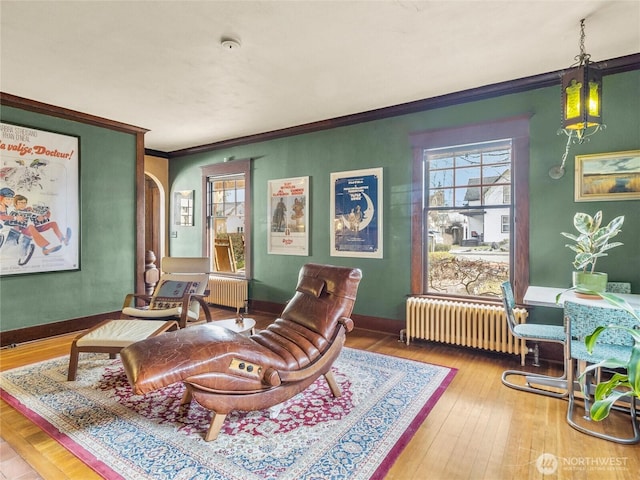 living room with crown molding, hardwood / wood-style flooring, and radiator heating unit