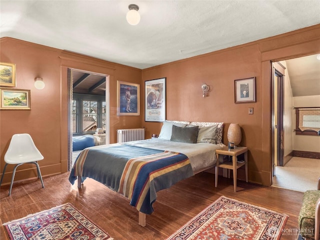 bedroom with radiator and hardwood / wood-style floors