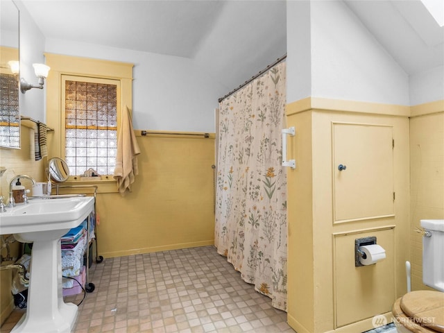 bathroom featuring walk in shower and vaulted ceiling