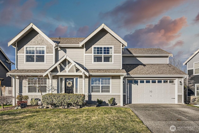 view of front of property with a garage and a lawn