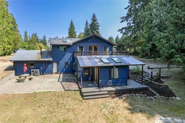 rear view of property featuring central AC, a deck, a patio, and a lawn