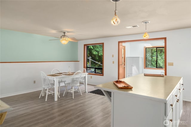 kitchen with pendant lighting, hardwood / wood-style floors, white cabinetry, and ceiling fan