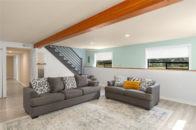 living room with beam ceiling and light wood-type flooring