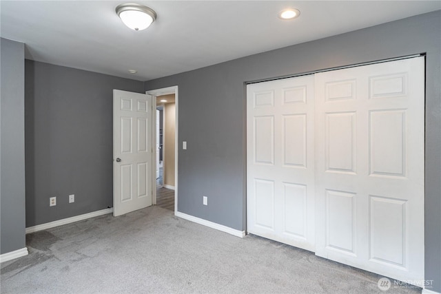 unfurnished bedroom with a closet and light carpet