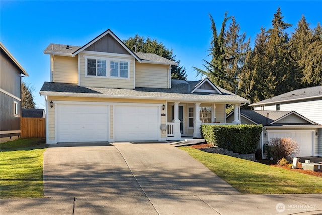 view of property featuring a porch, a garage, and a front lawn