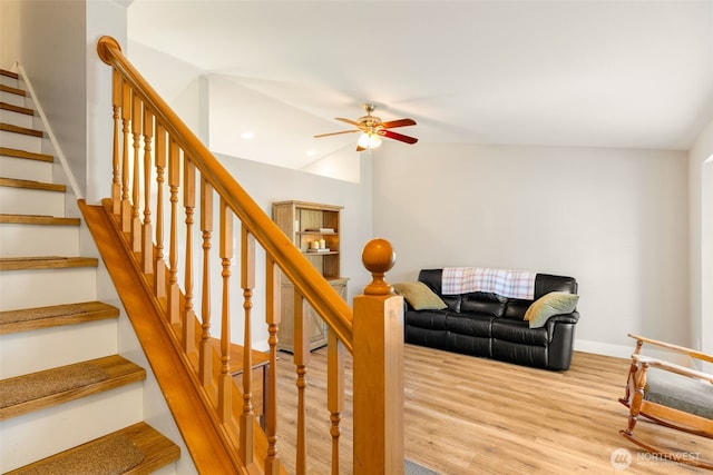 staircase with hardwood / wood-style flooring, lofted ceiling, and ceiling fan