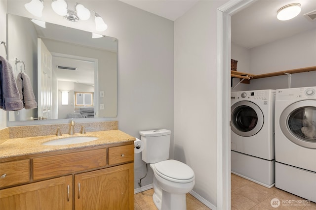 bathroom with washing machine and clothes dryer, tile patterned floors, toilet, and vanity