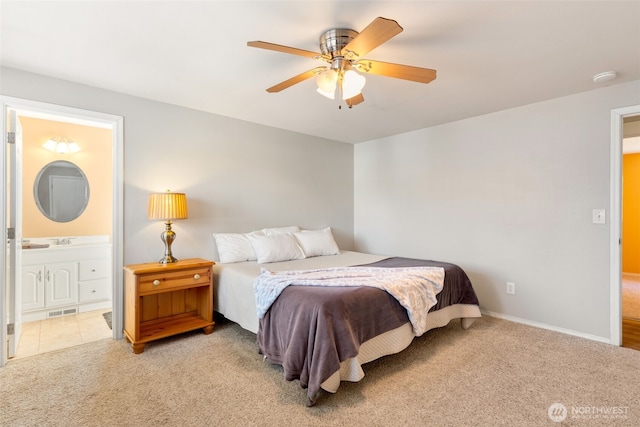 bedroom with light carpet, ceiling fan, and ensuite bathroom